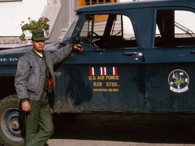 Jenn Pellegrino's father is leaning to a vehicle.